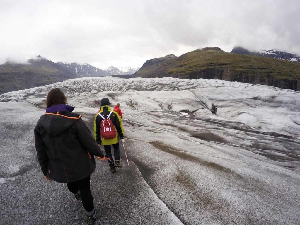 glacier walk pelo Vatnajökull. Na foto, duas pessoas aparecem fazendo a trilha sobre o gelo