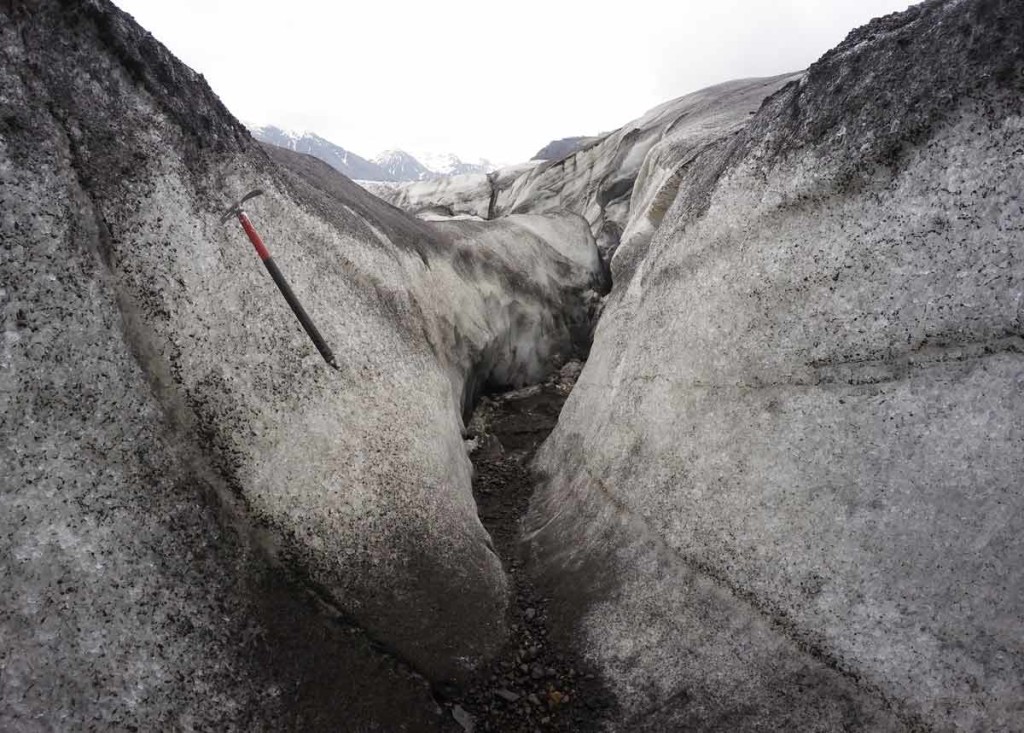 Caminhada no gelo na Islândia. Derretimento do gelo cria pequenos caminhos que são como fendas entre os blocos de gelo