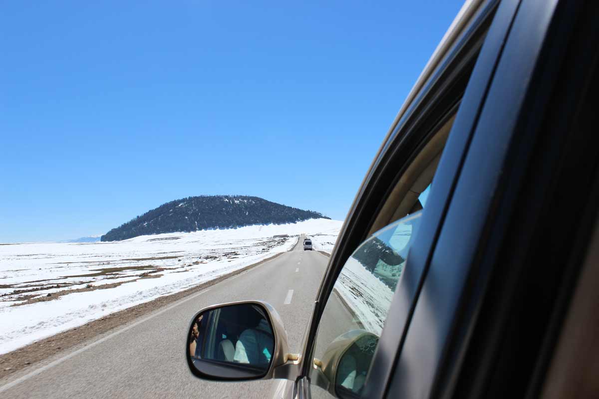 carro estrada montanhas a frente neve lado