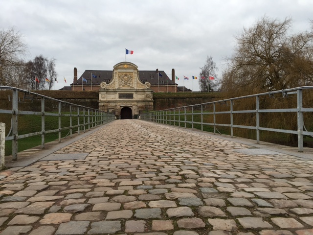 citadelle de lille. entrada sobre uma ponte de pedras para um dos prédios militares 