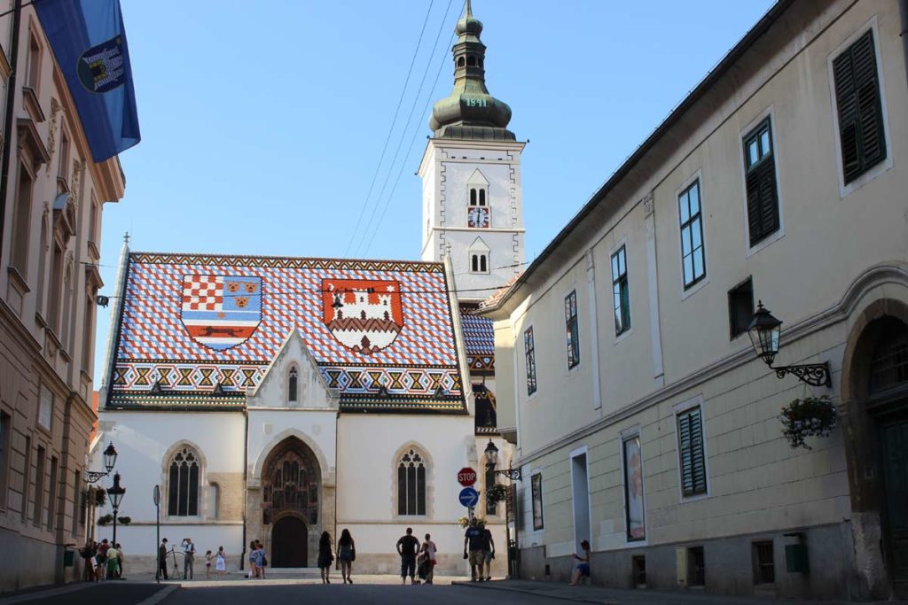 centro de zagreb na croácia - igreja possui um telhado vermelho com as cores e bandeirascroatas