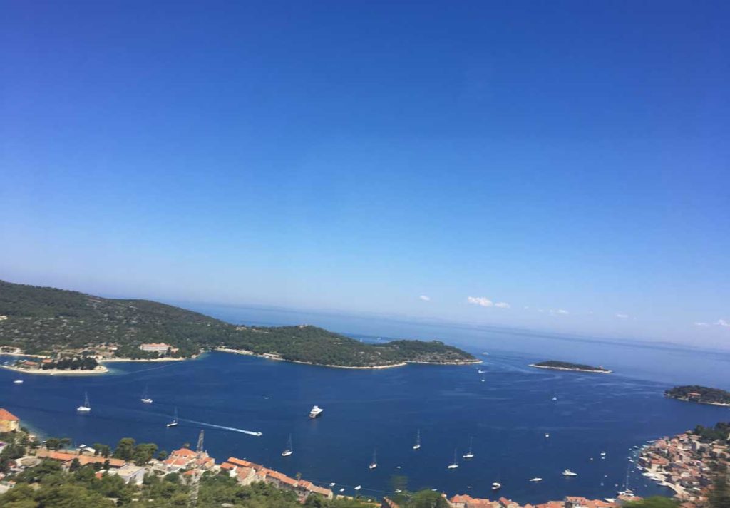 Vista aérea da ilha de vis, com a baía à frente rodeada por montanhas