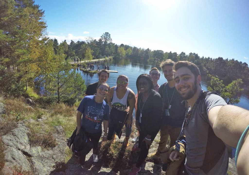 grupo reunido em parque na noruega com lago ao fundo