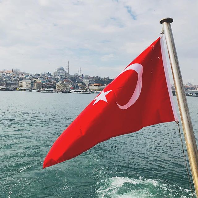 bandeira da turquia na proa de um barco com vista para a cidade de istambul