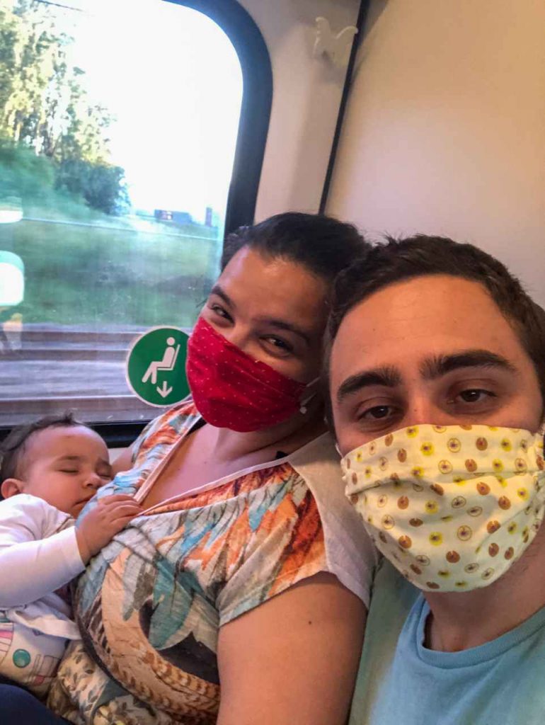 família viajando de trem de máscara