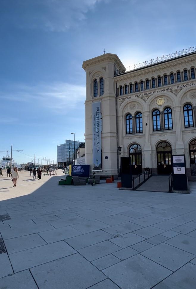 fachada do prédio do nobel piece center em frente aos barcos do porto de oslo